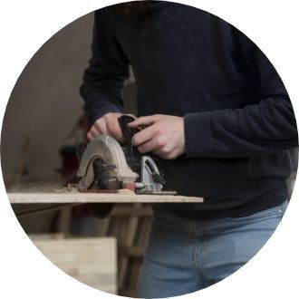 Man cutting wood board with hand saw