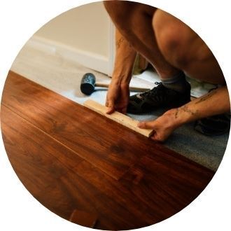 person installing hardwood flooring by hand